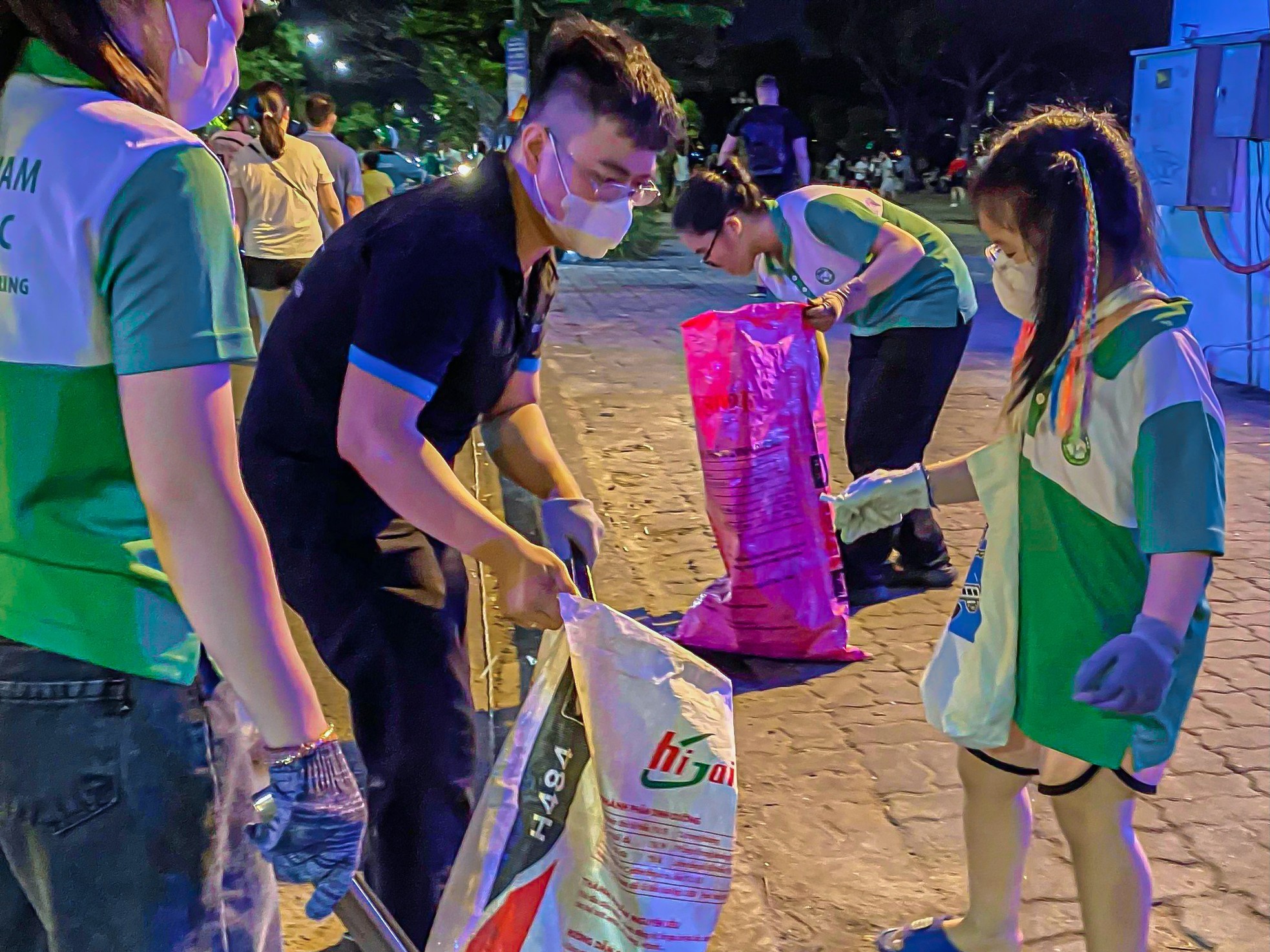 Hàng trăm bạn trẻ nán lại nhặt sạch rác sau đêm khai mạc lễ hội pháo hoa Đà Nẵng - Ảnh 8.