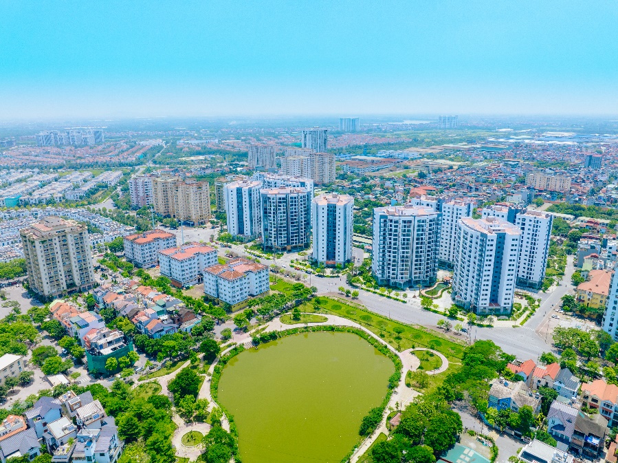 A city with many buildings and a pond  Description automatically generated