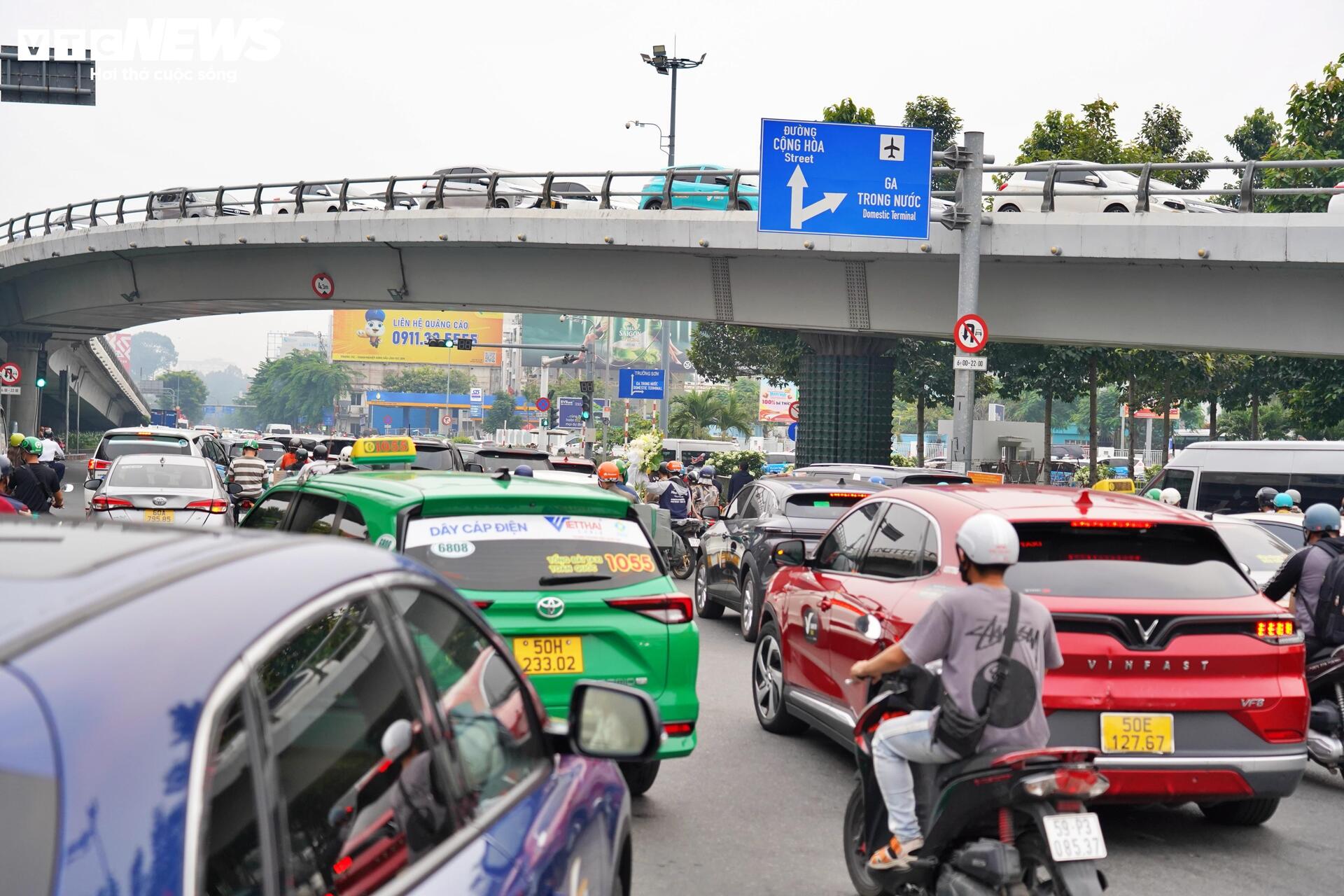 Sân bay Tân Sơn Nhất đông nghẹt chiều 24 Tết, hành khách vật vã ngồi chờ - Ảnh 3.