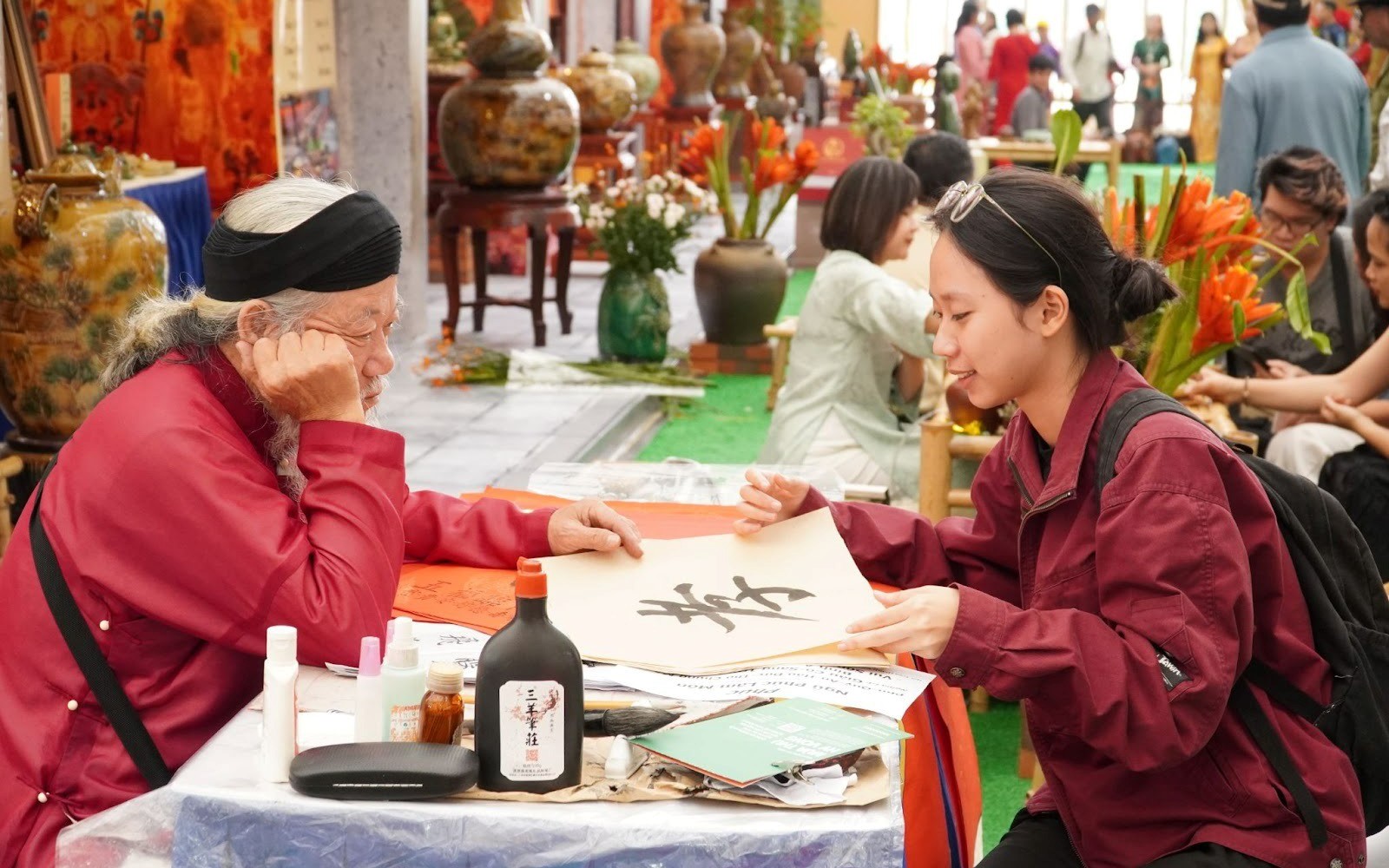 Du khách thích thú với trải nghiệm xin chữ, tự viết thư pháp tại Hội chợ Mùa Thu 2025