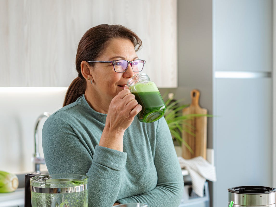 woman-in-kitchen-drinking-green-detox-drink-royalty-free-image-1765560401-1766921342091919126929-1766938370477-1766938371006797260154.jpg