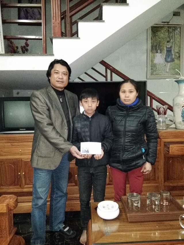 
Thầy Vũ Trọng Hoài thay mặt một số nhà hảo tâm trao tặng khoản tiền nhỏ cho mẹ con cậu bé Trần Thế Bảo. Ảnh. TH.
