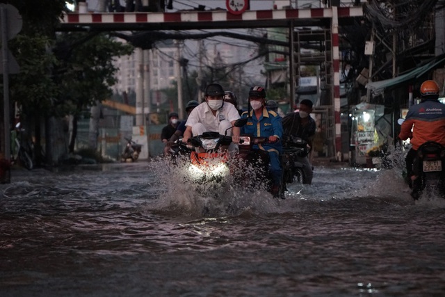 Người dân Sài Gòn vất vả lội nước về nhà trong đợt triều cường cao nhất từ đầu năm - Ảnh 4.
