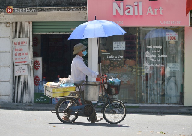 Nắng nóng đỉnh điểm từ đầu hè lên đến 40 độ C tại Hà Nội: Nhựa đường tan chảy, người dân dùng nước tưới đường giữa trưa - Ảnh 11.