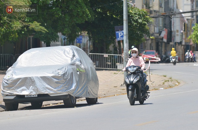 Nắng nóng đỉnh điểm từ đầu hè lên đến 40 độ C tại Hà Nội: Nhựa đường tan chảy, người dân dùng nước tưới đường giữa trưa - Ảnh 10.