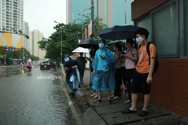 Mưa lớn như trút nước sáng 12/6, phụ huynh Hà Nội xách dép, đội mưa đưa con đi thi vào lớp 10 - Ảnh 2.