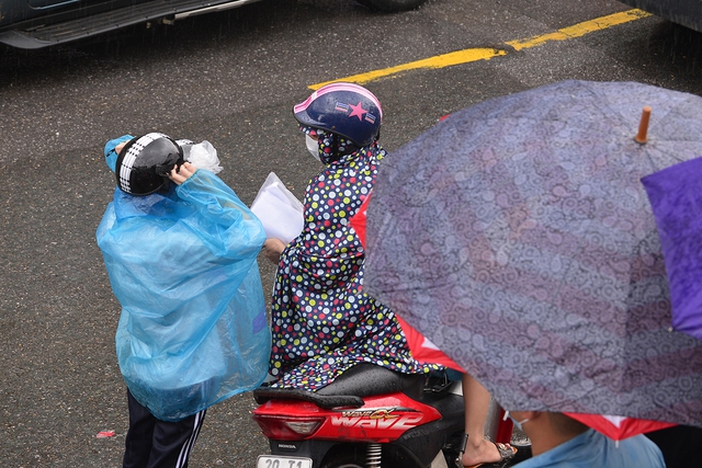 Hình ảnh phụ huynh đội mưa đón thí sinh trong cơn mưa tầm tã sau buổi thi cuối tuyển sinh vào lớp 10 - Ảnh 9.