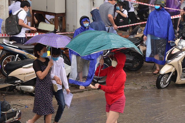 Hình ảnh phụ huynh đội mưa đón thí sinh trong cơn mưa tầm tã sau buổi thi cuối tuyển sinh vào lớp 10 - Ảnh 3.