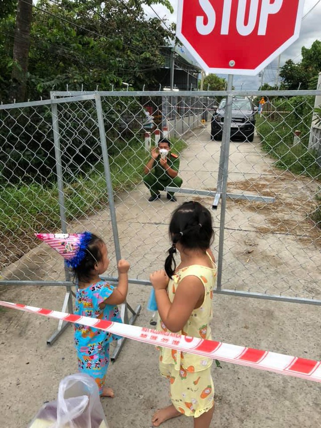 Chiến sĩ công an mừng sinh nhật con gái ngay tại hàng rào phong tỏa, cái vẫy tay từ xa khiến bao người thổn thức - Ảnh 1.