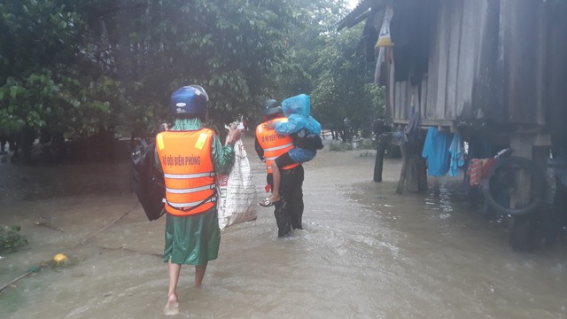 Lực lượng chức năng di dời người dân ra khỏi vùng nguy hiểm do mưa lũ - Ảnh 2.