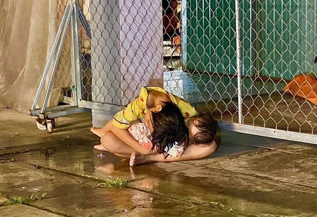 Nghẹn ngào hai bé gái ôm nhau ngủ gục dưới cơn mưa lớn, CĐM: &quot;Hi vọng các con không phải trẻ mồ côi&quot; - Ảnh 1.