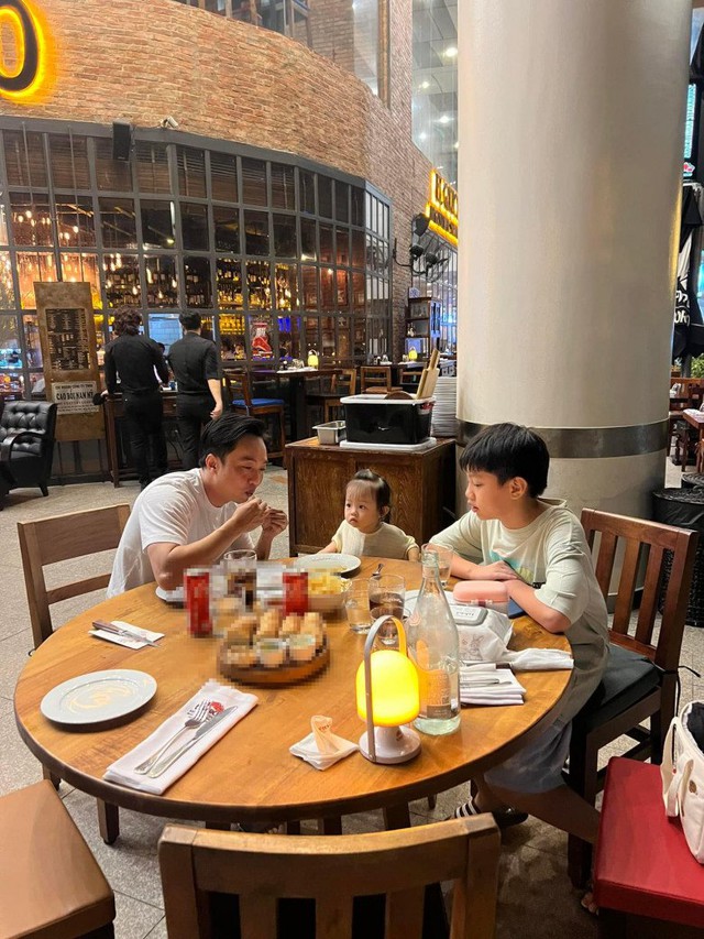 Vợ vắng nh&agrave;, Cường Đ&ocirc;la khoe đưa 2 con đ&aacute;nh lẻ ăn ngo&agrave;i, tr&ecirc;n b&agrave;n c&oacute; chiếc t&uacute;i nữ khả nghi - Ảnh 2.