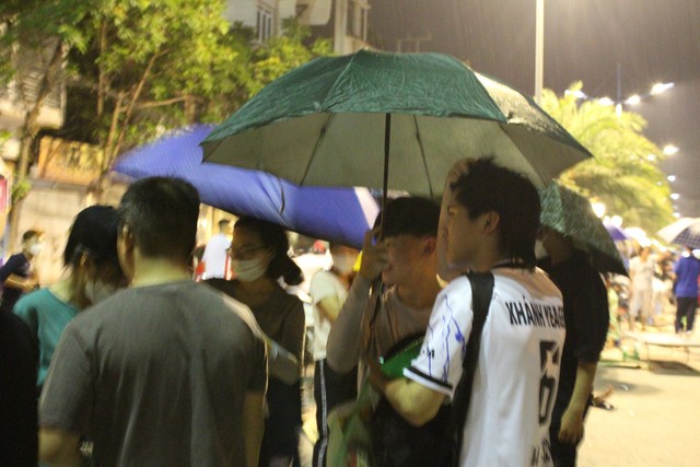 Quảng Ninh: Hình ảnh người hâm mộ đội mưa thức thâu đêm chờ nhận vé chung kết bóng đá nữ - Ảnh 2.