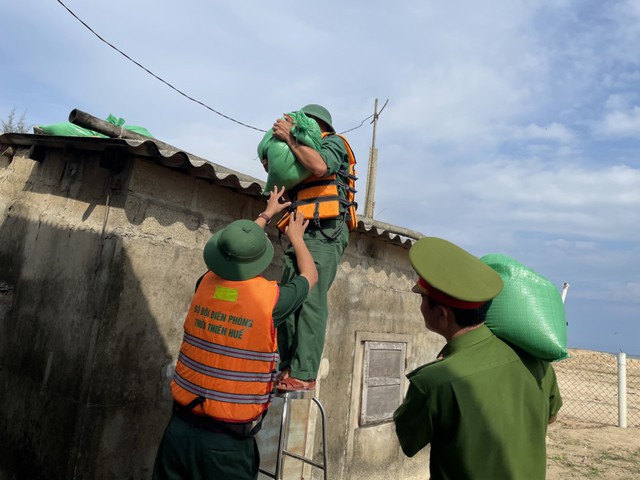 Ảnh: Biên phòng, công an giúp dân chằng chống nhà cửa, đưa tàu thuyền vào bờ ứng phó bão Noru - Ảnh 10.