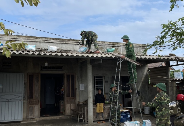 Ảnh: Biên phòng, công an giúp dân chằng chống nhà cửa, đưa tàu thuyền vào bờ ứng phó bão Noru - Ảnh 2.