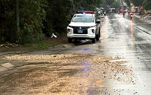 Cảnh sát giao thông thu dọn đất đá rơi vãi trên đường do mưa lớn - Ảnh 1.