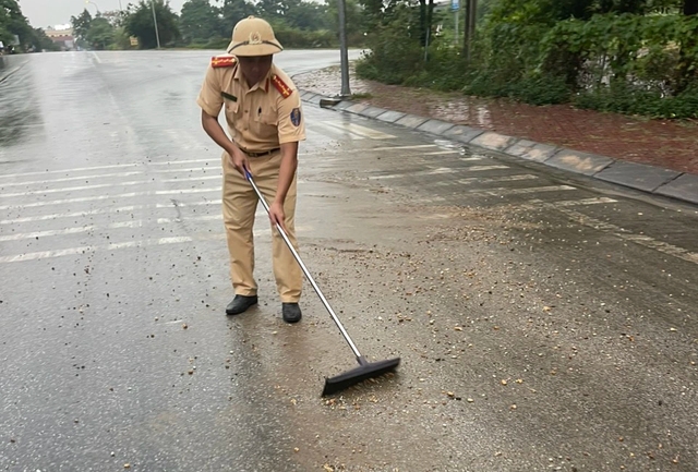 Cảnh sát giao thông thu dọn đất đá rơi vãi trên đường do mưa lớn - Ảnh 2.