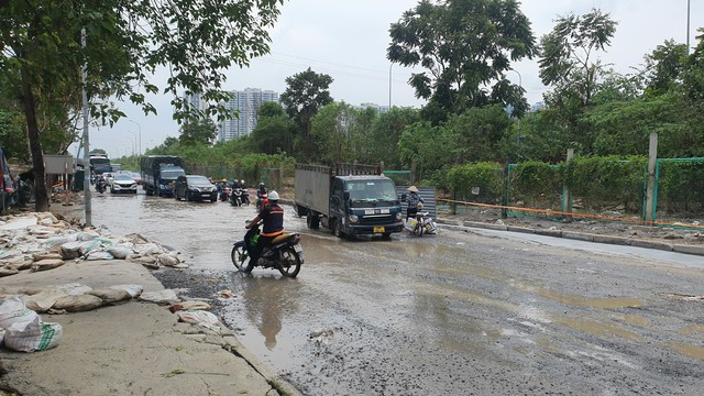 Đoạn đường gom Đại lộ Thăng Long bị ngập trong nước, người dân di chuyển chật vật- Ảnh 1.