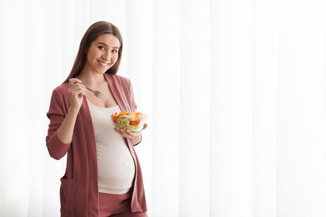 nutrition-during-pregnancy-smiling-pregnant-lady-eating-fresh-vegetable-salad-17615403005731894042845.jpeg
