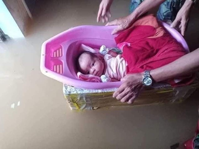 Những hình ảnh người dân oằn mình trong cơn lũ - Ảnh 1.