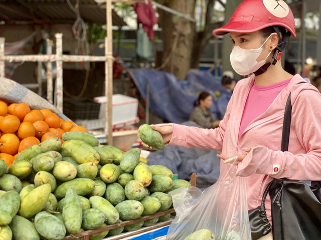 Tiểu thương bật m&iacute; nguồn gốc của một loại xo&agrave;i gi&aacute; rẻ, hạt mỏng d&iacute;nh đang b&aacute;n đầy chợ Việt - Ảnh 2.