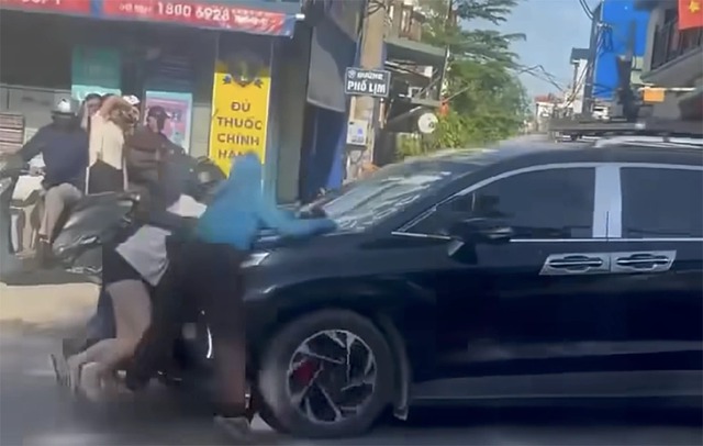 Hà Nội: Xôn xao cảnh ba người phụ nữ đu bám trên nắp capo xe ô tô con ở Phú Xuyên - Ảnh 2.