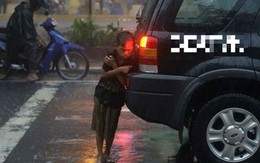Cậu bé đứng co ro dưới mưa sau đuôi xe ô tô lay động triệu trái tim