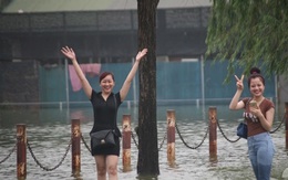 Thật bất ngờ: Mặc kệ đường ngập sau mưa, chị em Hà Nội vẫn tươi cười "vượt lũ"