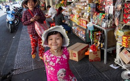 Nét hồn nhiên của bé gái "chim cánh cụt" theo bà bán vé số ở trung tâm Sài Gòn