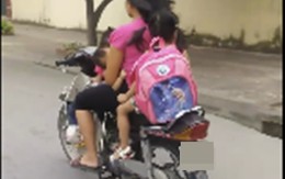 Người mẹ chạy xe máy bằng một tay, một tay bế con bú khiến người đi đường sợ hãi