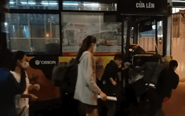 Nhiều sinh viên cùng nhau đẩy chiếc xe buýt chết máy qua đoạn đường hẹp ở Hà Nội