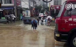 Cụ ông cõng vợ lội qua vũng nước
