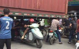 Bất chấp nguy hiểm, người dân thi nhau chui gầm container chắn ngang giữa đường để lưu thông