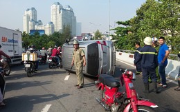 TP.HCM: Ô tô 7 chỗ lật nhào trên đường phố, tài xế bung cửa thoát thân