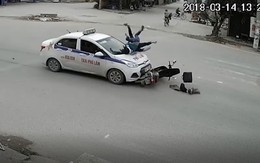 Phóng nhanh qua ngã tư, 2 người đi xe máy bị taxi hất lên nắp capo