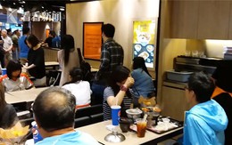 Bà mẹ cho con đi tè vào cốc uống trà ở nhà hàng