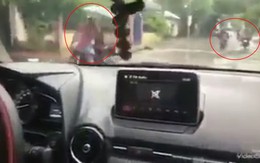 Người phụ nữ đạp chân ga, bé trai cầm vô lăng điều khiển ô tô giữa trời mưa khiến nhiều người hốt hoảng