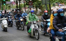 Giữa trưa, người Hà Nội vẫn mặc áo mưa tránh cái rét nhất từ đầu đông