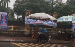 Xúc động clip nữ tình nguyện viên chạy hộc tốc che mưa cho thí sinh đi muộn