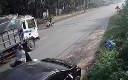 Mở cửa ô tô bất cẩn khiến 2 người suýt mất mạng dưới gầm xe tải
