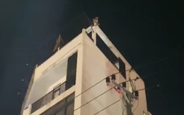 Giải cứu người đàn ông ngồi vắt vẻo trên nóc toà nhà 4 tầng trong đêm