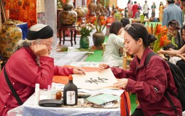 Du khách thích thú với trải nghiệm xin chữ, tự viết thư pháp tại Hội chợ Mùa Thu 2025