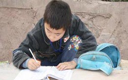 Cậu bé học bài bên lề đường