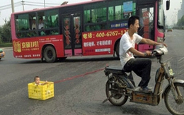 Cho con vào sọt nhựa kéo lê trên phố