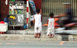 Hai bé trai quỳ gối trên đại lộ Đông Tây