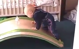 Em bé đáng yêu và nỗ lực lấy bình sữa