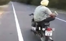 Quái xế Ấn Độ vừa đi xe máy vừa vắt chân đọc báo