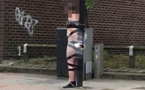 Chàng trai bị lột hết quần áo, trói băng dính vào cột đèn giao thông