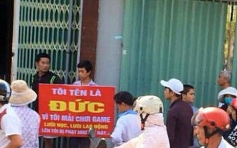 Mẹ cùng con trai cầm bảng phạt đứng giữa đường vì con mải chơi game