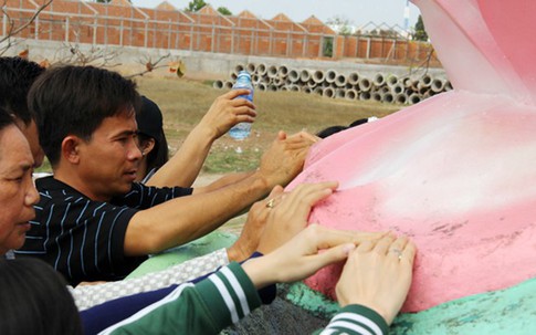 Hứng nước dưới tượng Phật bà rửa mặt cầu may